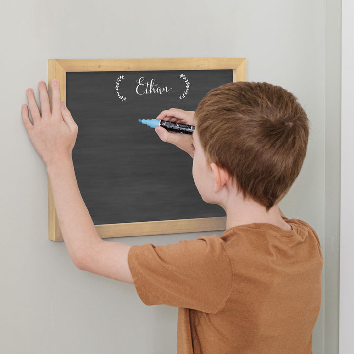 A framed whiteboard reward chart hanging on the wall