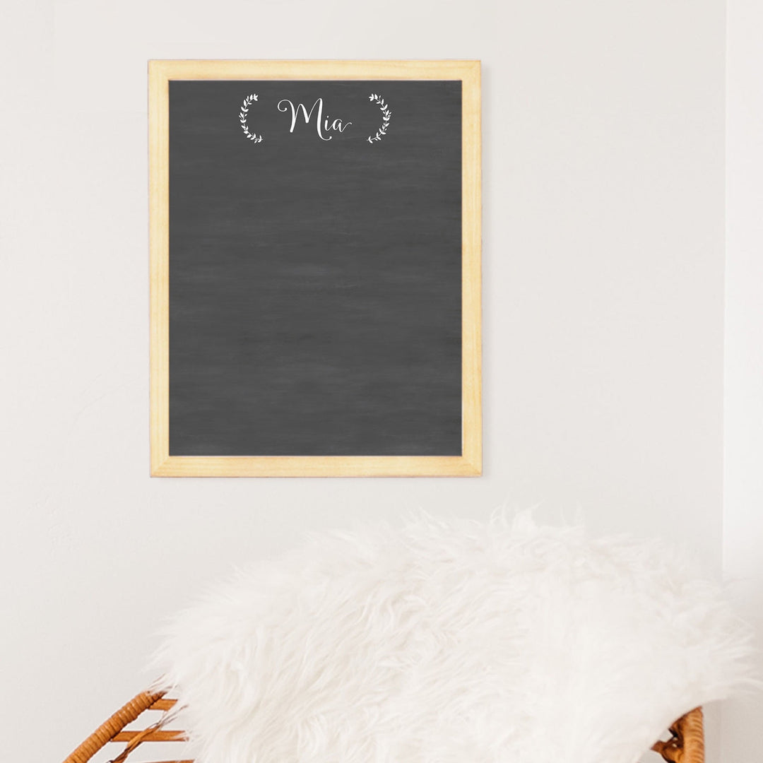 A framed dry-erase reward chart with a chalkboard look hanging on the wall