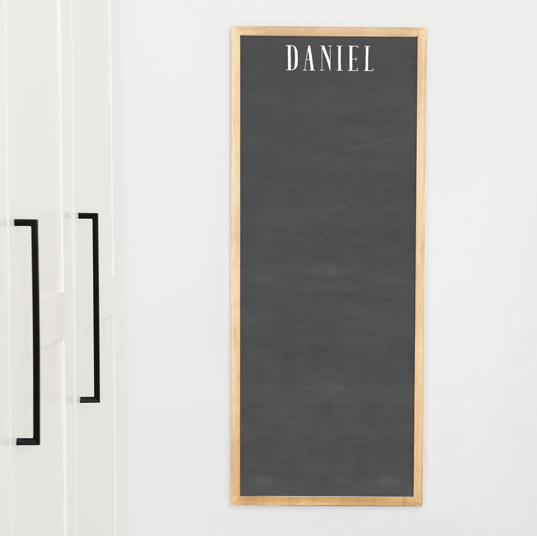 A framed dry-erase chalkboard calendar with a two month design format hanging on the wall