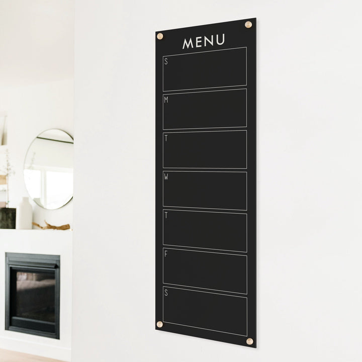 A skinny dry-erase weekly calender made of acrylic hanging on the wall