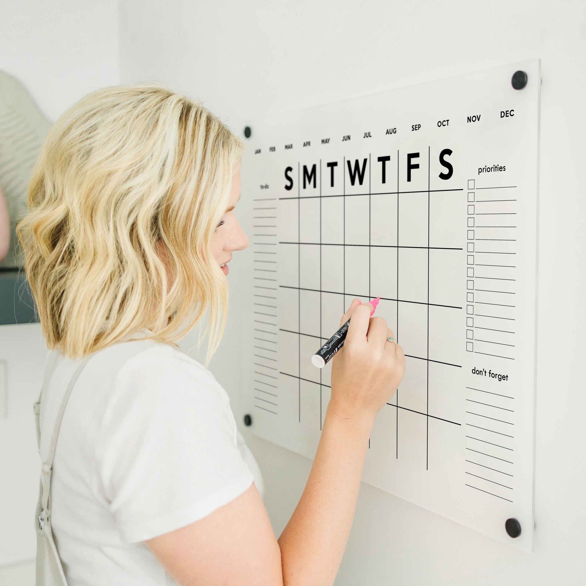 A Dry-erase monthly calender made of acrylic hanging on the wall