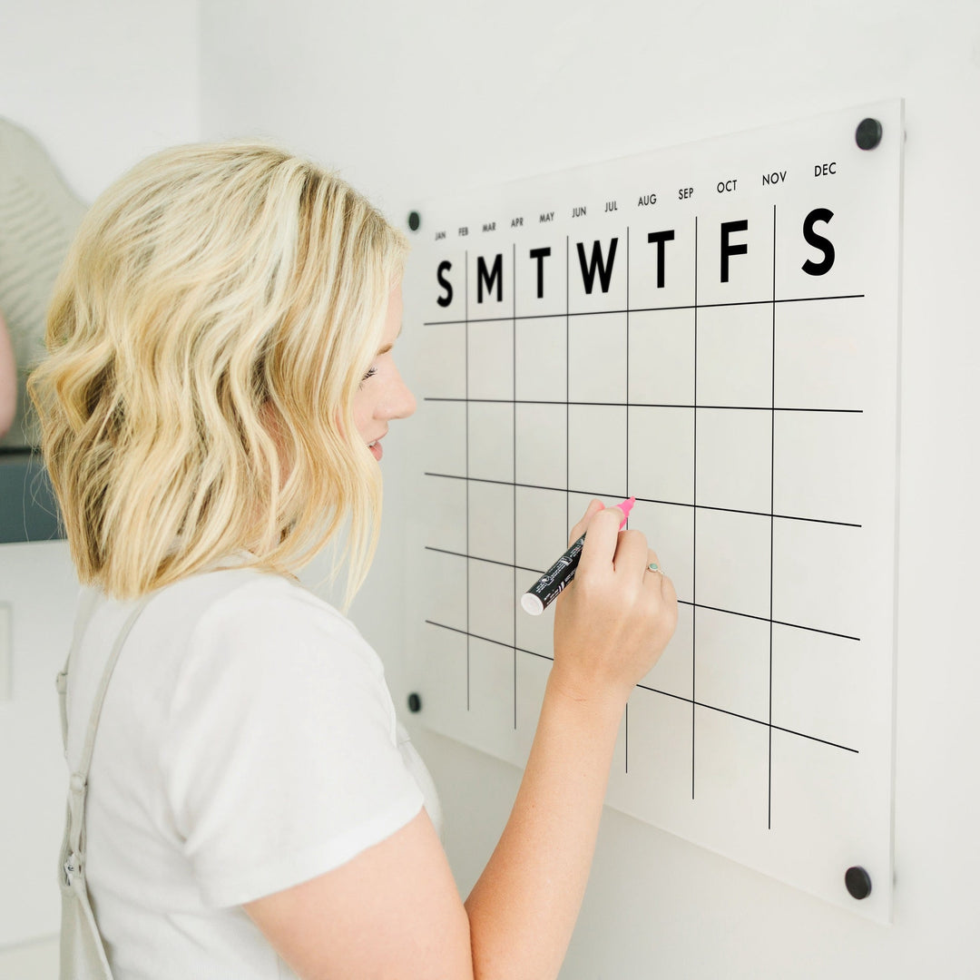 A Dry-erase monthly calender made of acrylic hanging on the wall