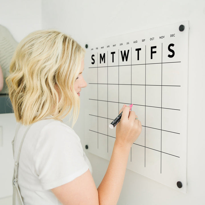 A Dry-erase monthly calender made of acrylic hanging on the wall