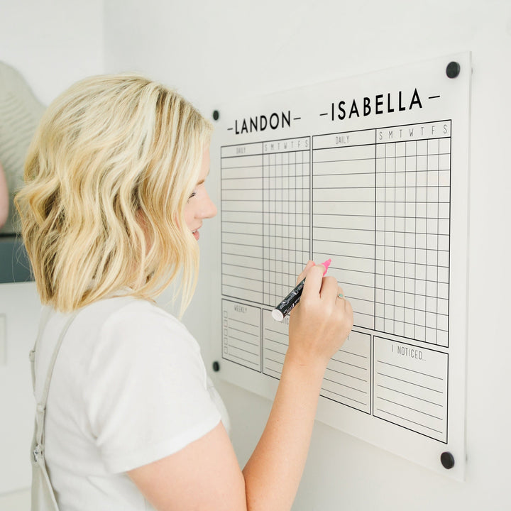 A Dry-erase acrylic chore chart hanging on the wall