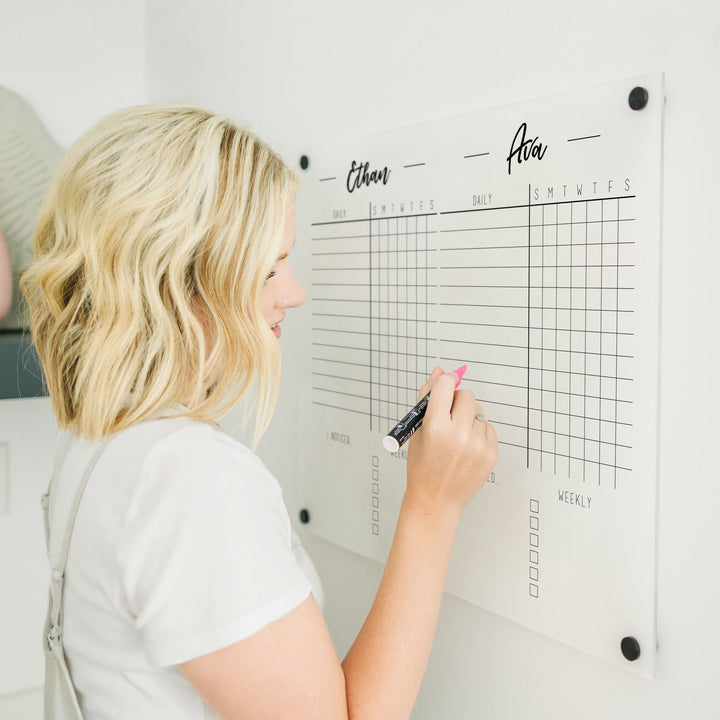 A Dry-erase acrylic chore chart hanging on the wall