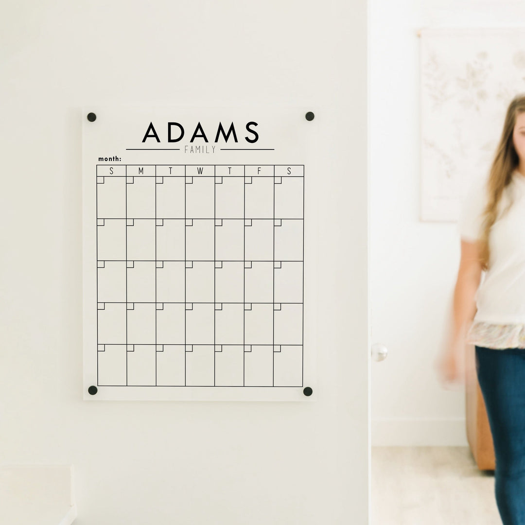 A Dry-erase monthly calender made of acrylic hanging on the wall