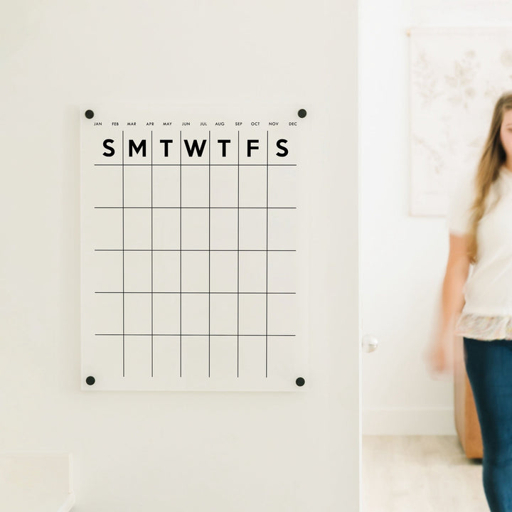 A Dry-erase monthly calender made of acrylic hanging on the wall
