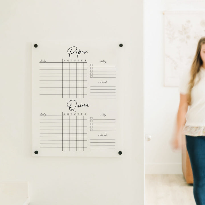 A Dry-erase acrylic chore chart hanging on the wall