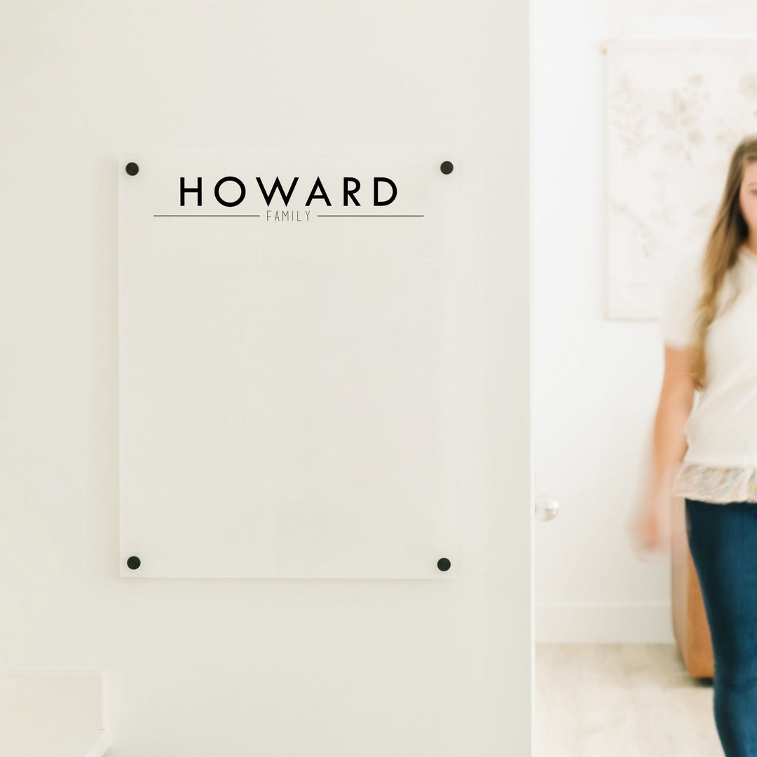 A dry-erase board made of clear acrylic with a custom title up top