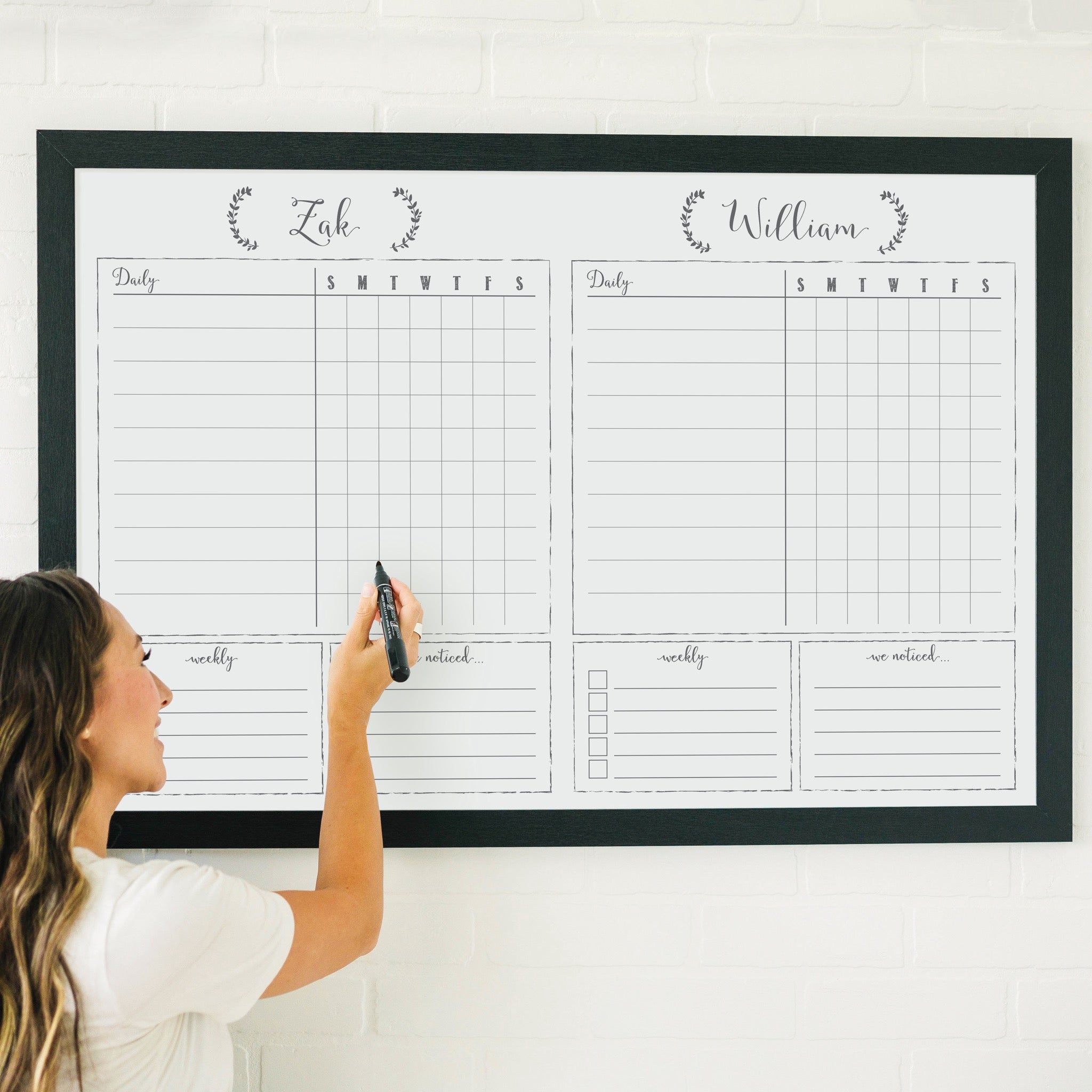 A framed whiteboard chore chart hanging on the wall