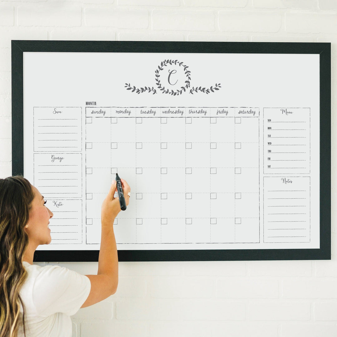 A framed whiteboard family command center hanging on the wall