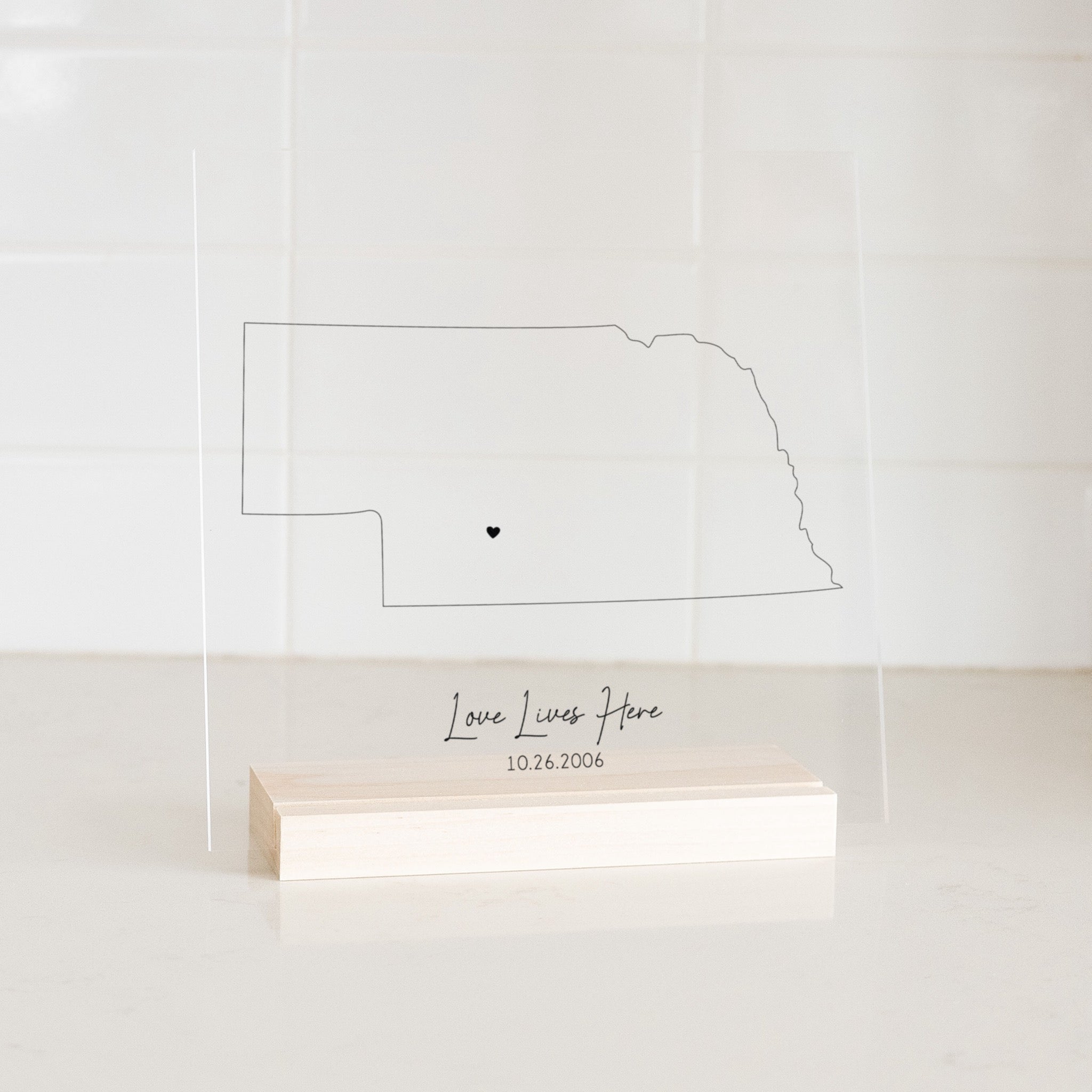 Clear acrylic sign with wood base featuring a Nebraska location and custom text