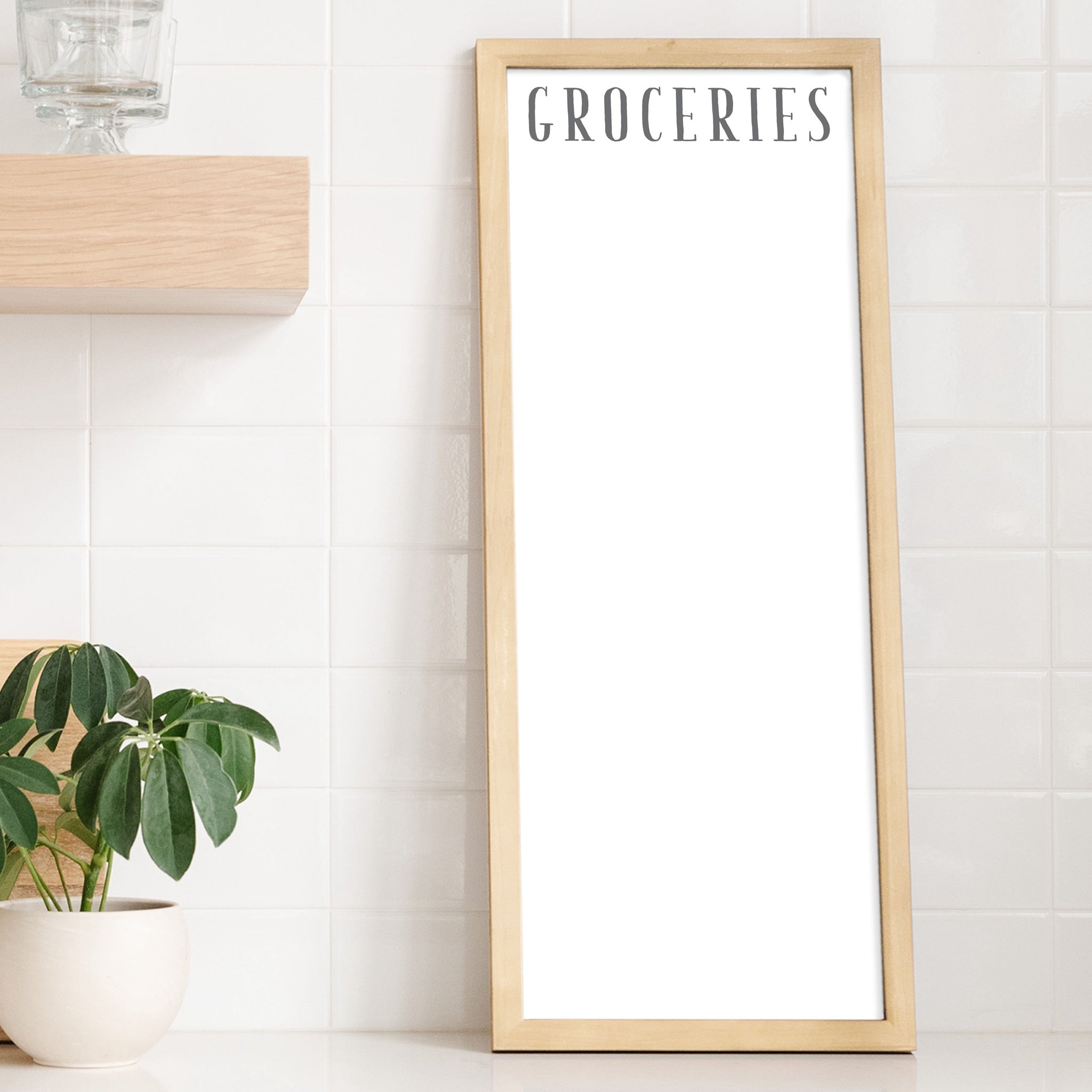 A framed whiteboard calendar with a two month design format hanging on the wall