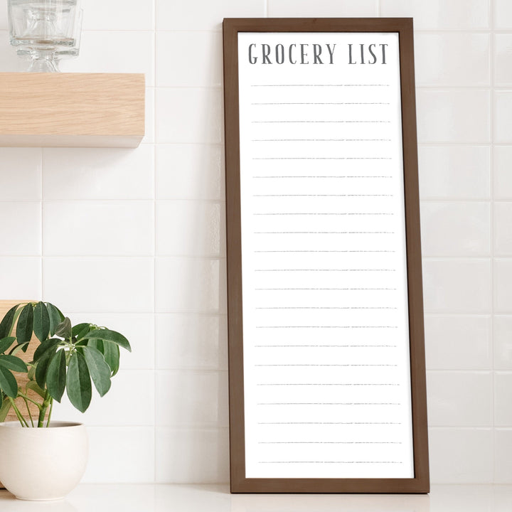 A framed whiteboard to do list hanging on the wall