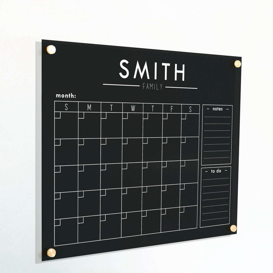 A Dry-erase monthly calender made of acrylic hanging on the wall