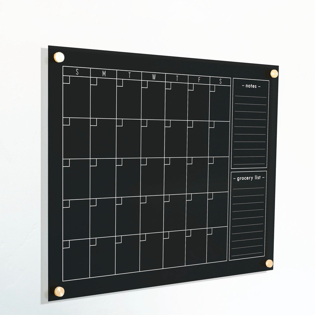 A Dry-erase monthly calender made of acrylic hanging on the wall