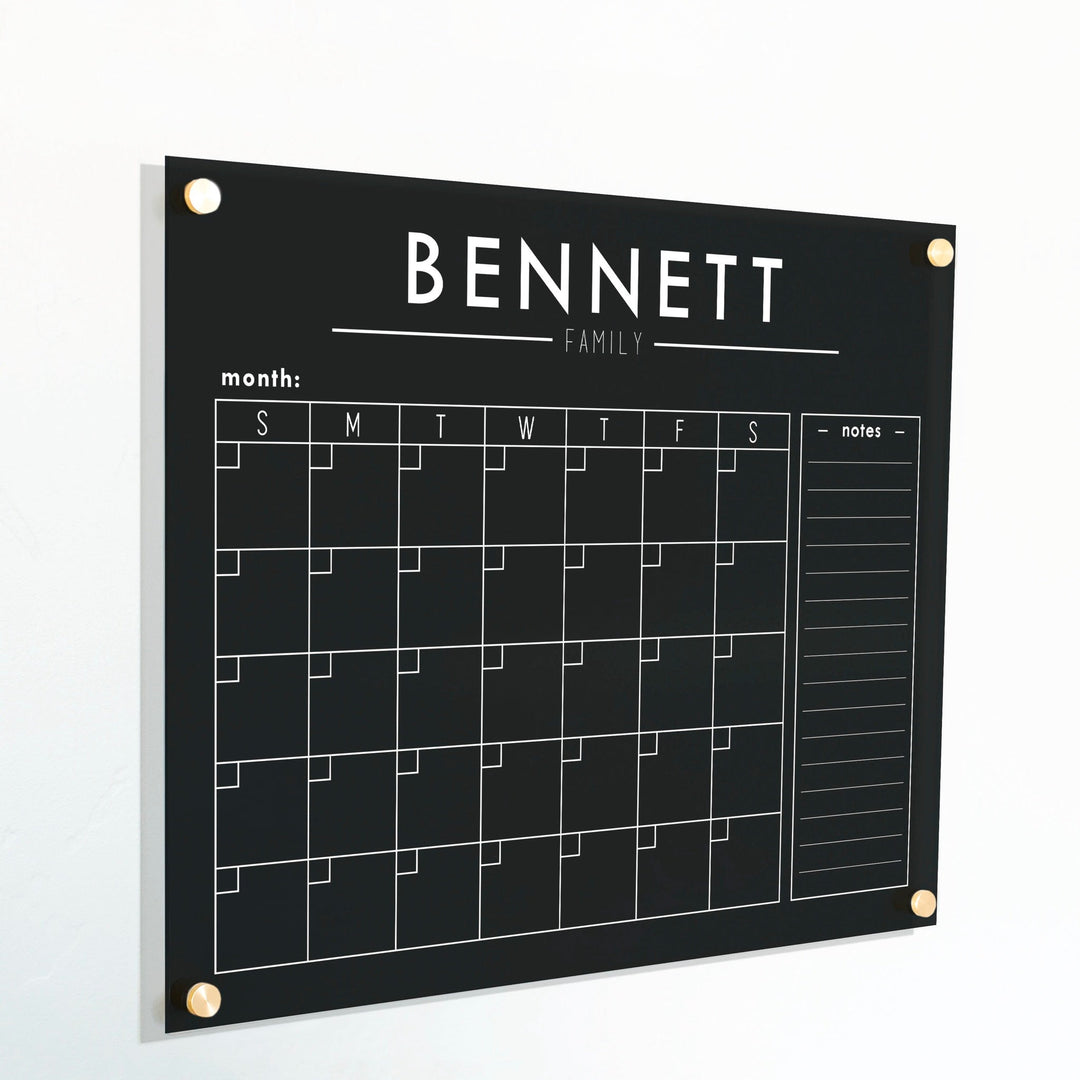 A Dry-erase monthly calender made of acrylic hanging on the wall