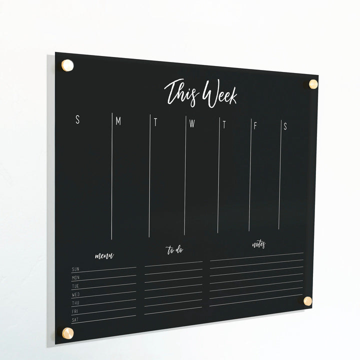 A Dry-erase weekly calender made of acrylic hanging on the wall