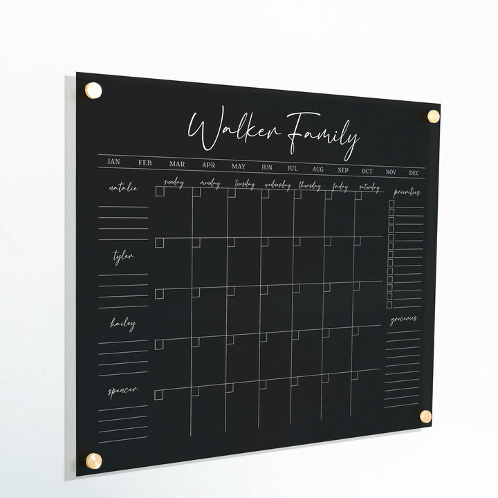 A Dry-erase family command center made of acrylic hanging on the wall