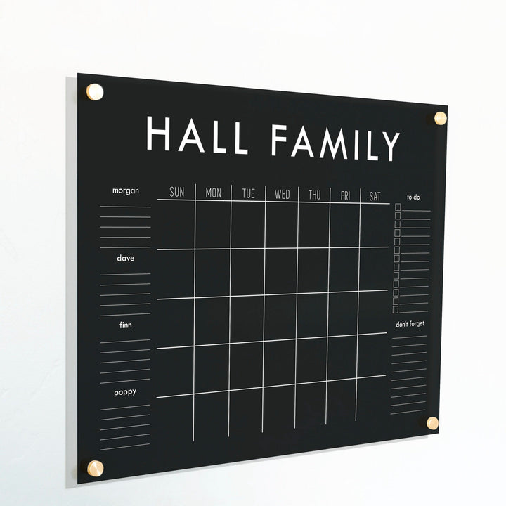 A Dry-erase family command center made of acrylic hanging on the wall