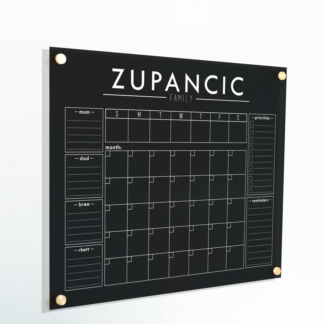 A Dry-erase calendar with a monthly and weekly format made of acrylic hanging on the wall