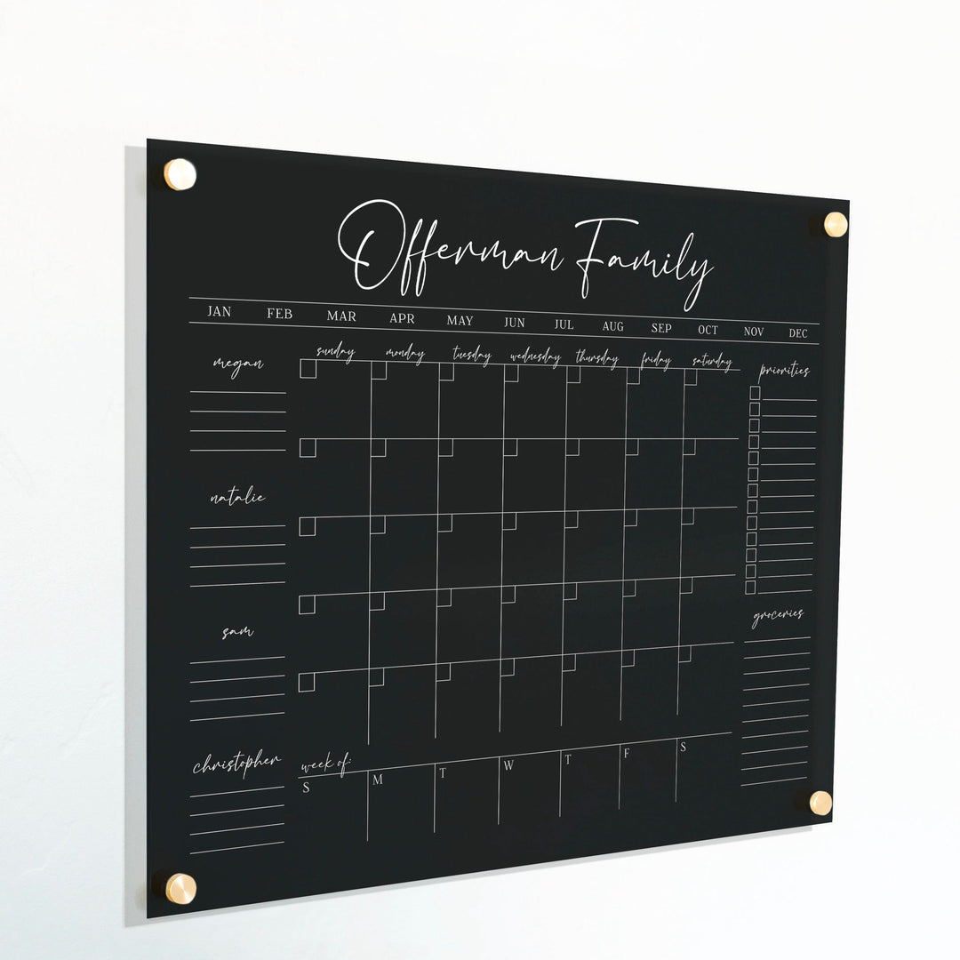 A Dry-erase calendar with a monthly and weekly format made of acrylic hanging on the wall