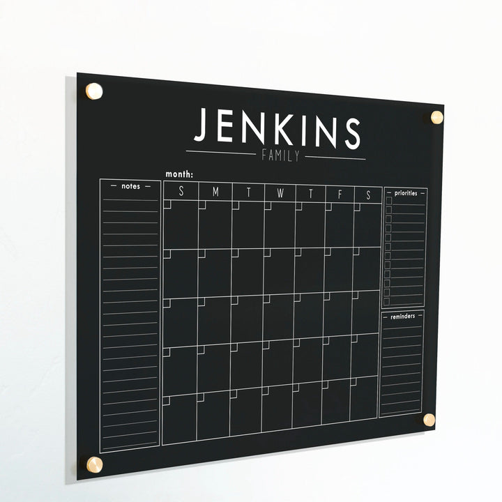 A Dry-erase monthly calender made of acrylic hanging on the wall