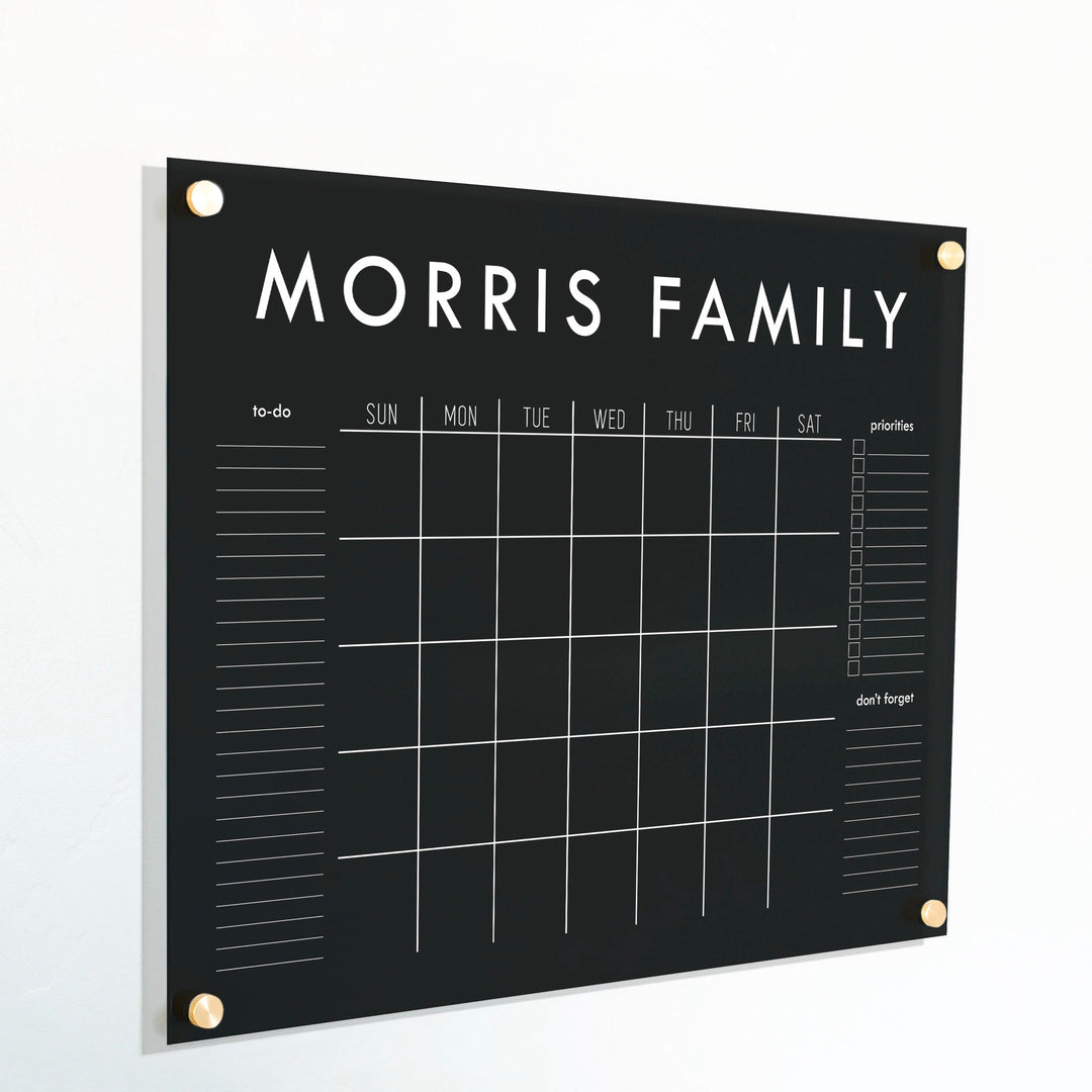 A Dry-erase monthly calender made of acrylic hanging on the wall