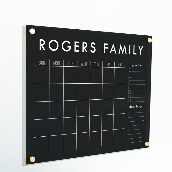 A Dry-erase monthly calender made of acrylic hanging on the wall