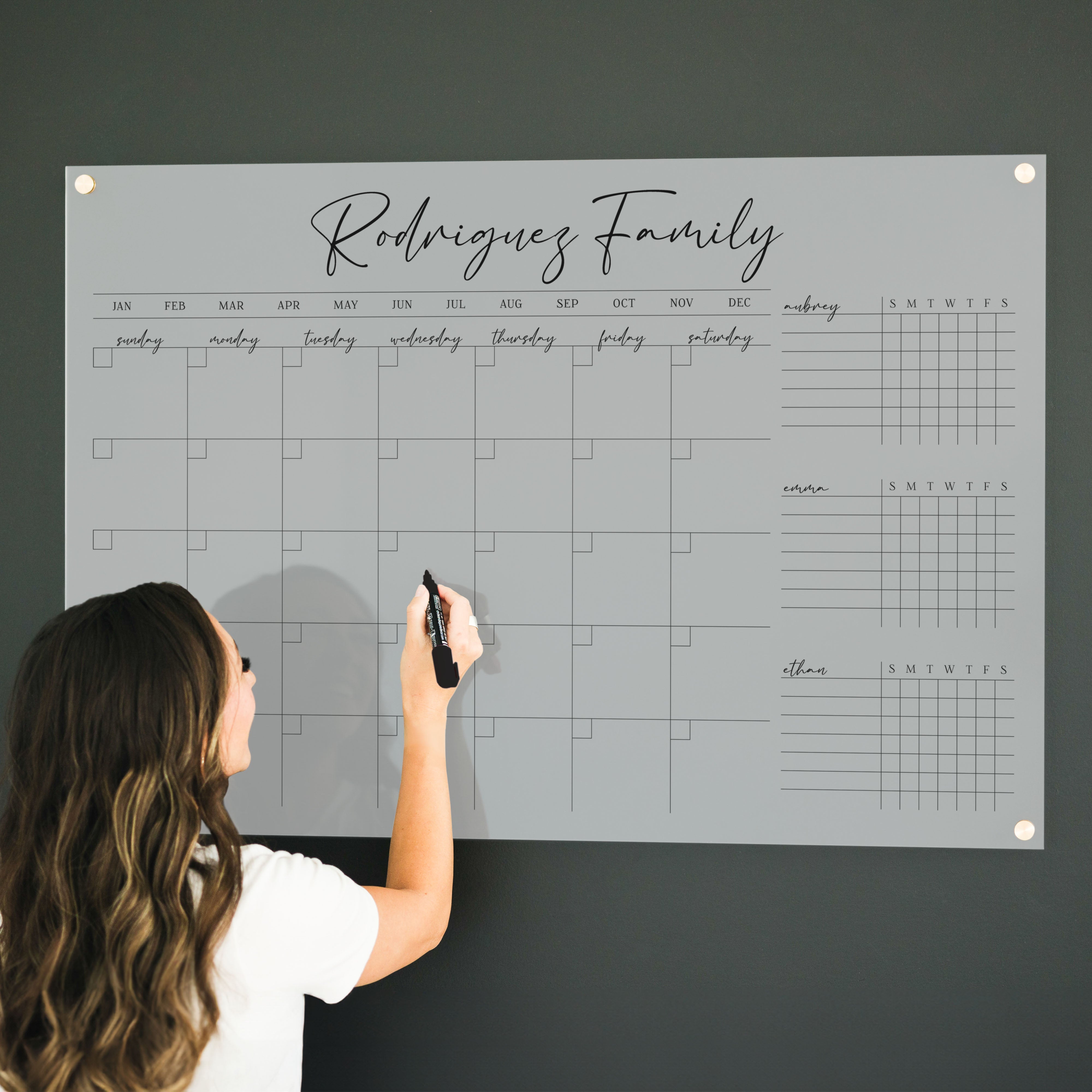 A dry-erase board with a month calendar and chore chart on it