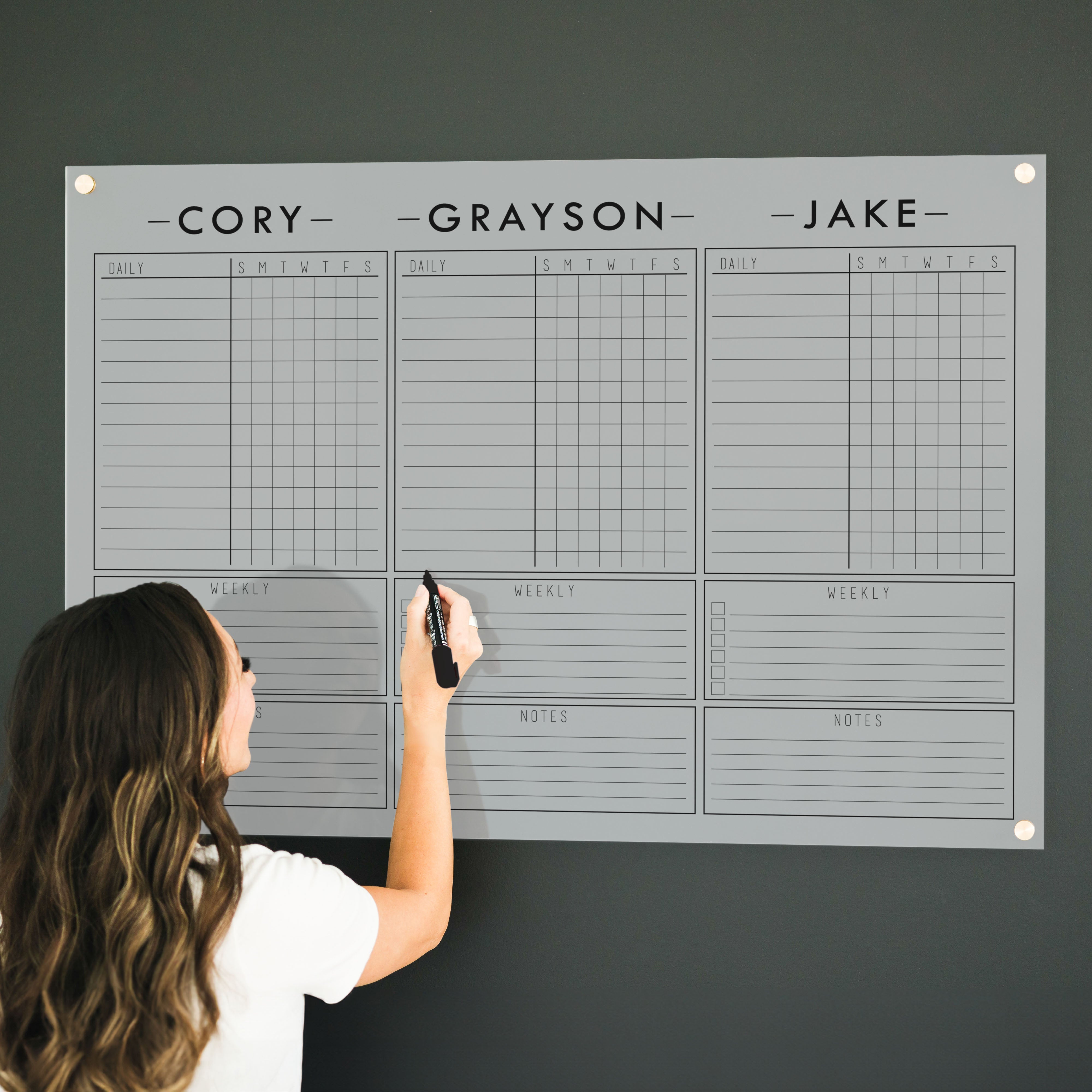 A Dry-erase acrylic chore chart hanging on the wall