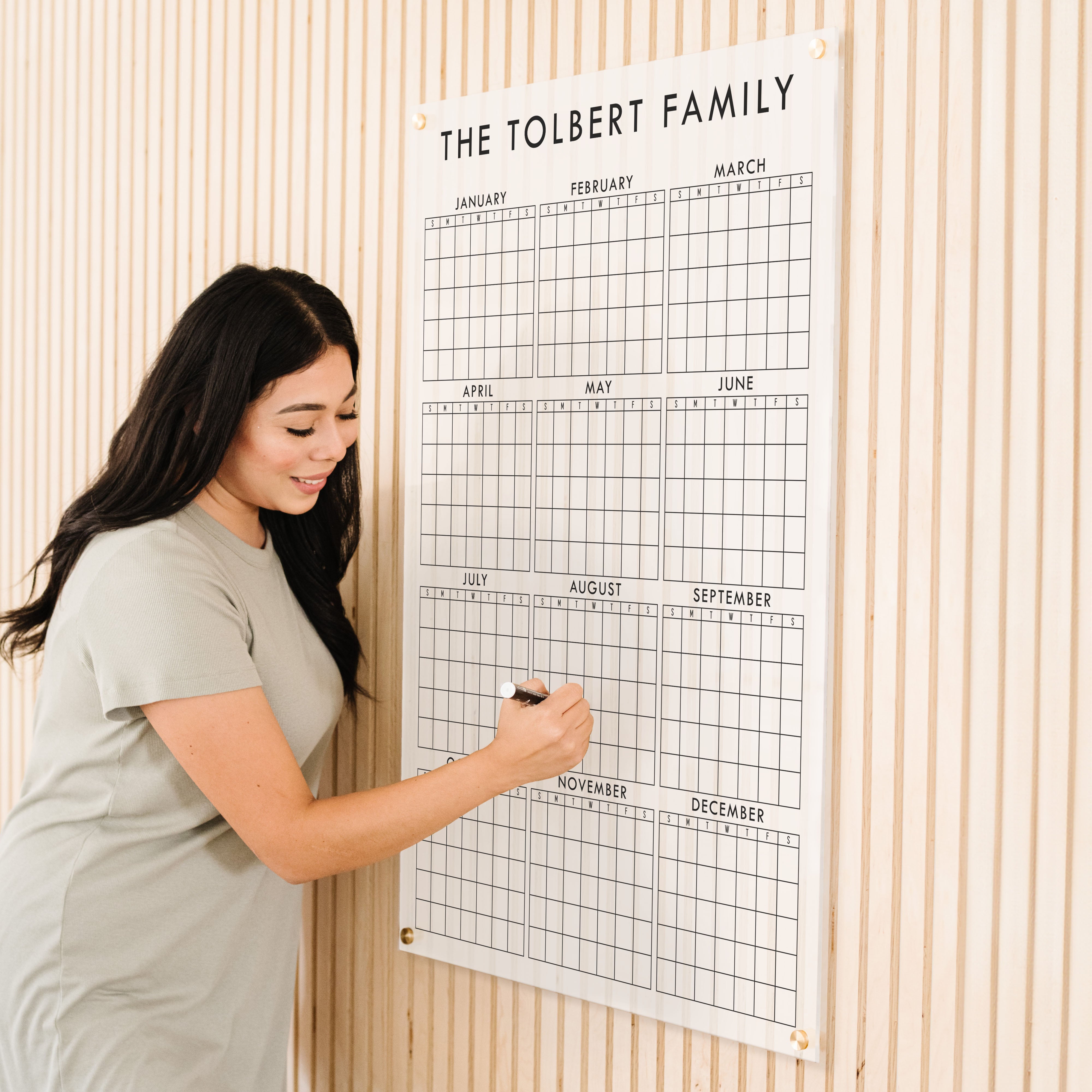 A dry-erase yearly calendar made of acrylic hanging up on the wall