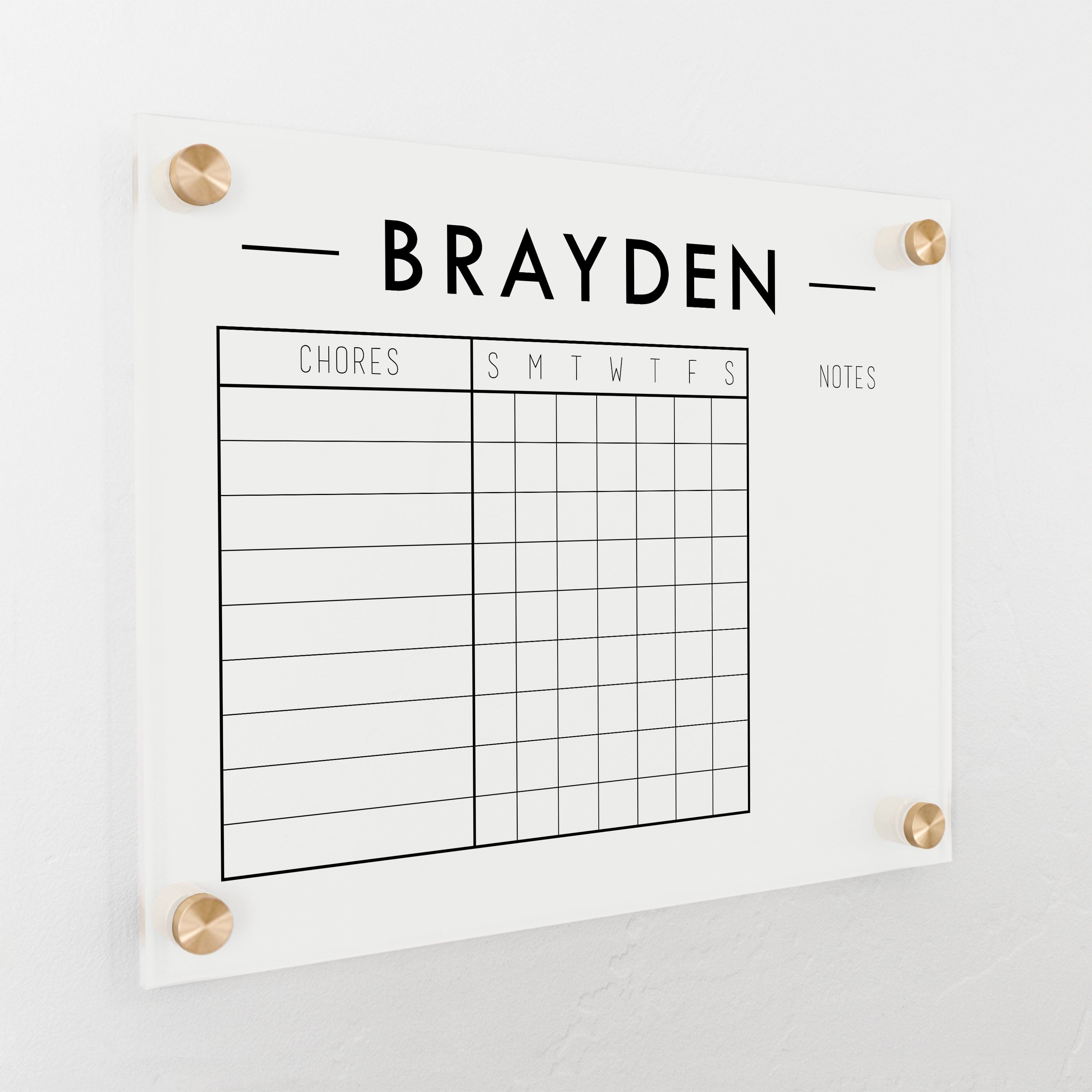 A Dry-erase acrylic chore chart hanging on the wall