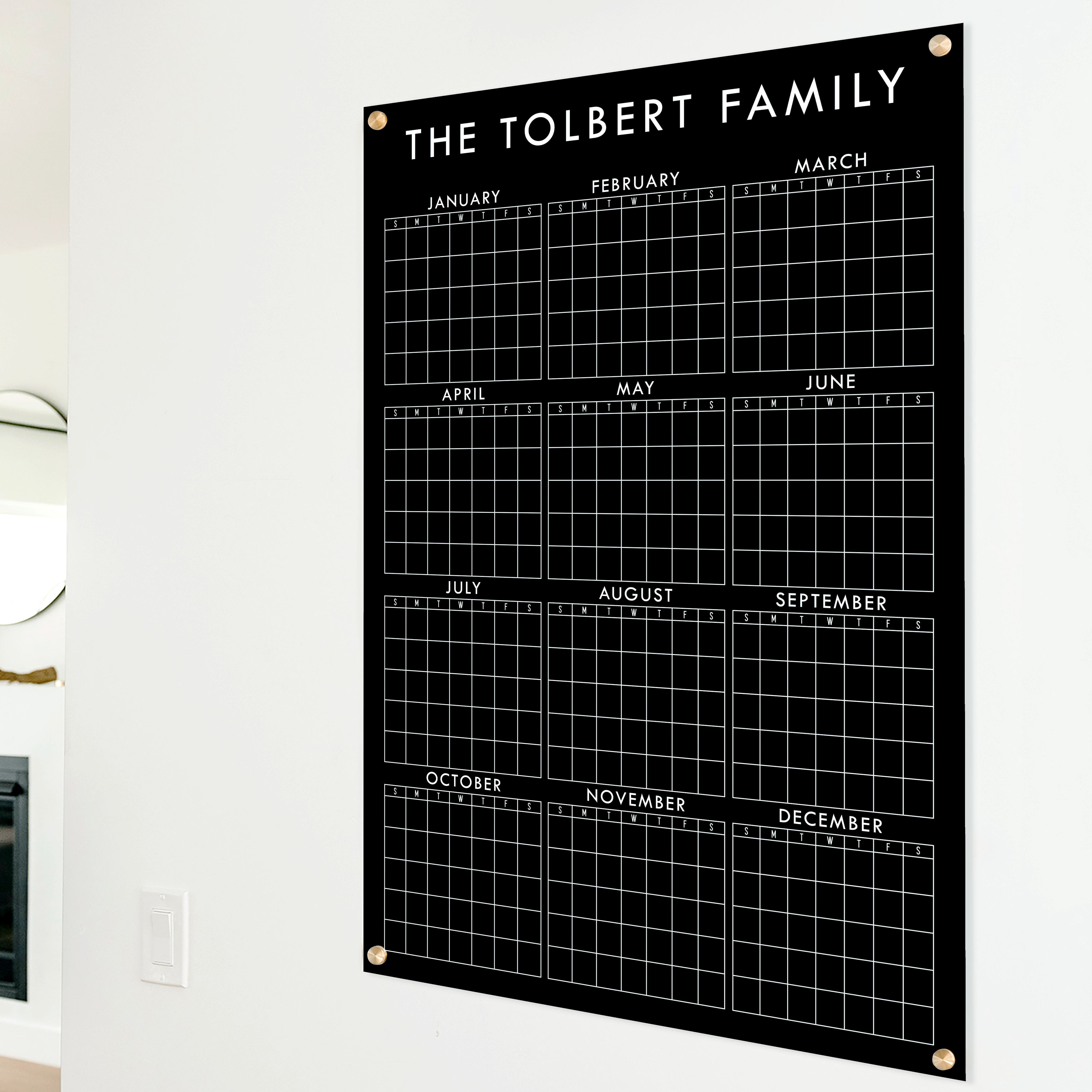 A dry-erase yearly calendar made of acrylic hanging up on the wall