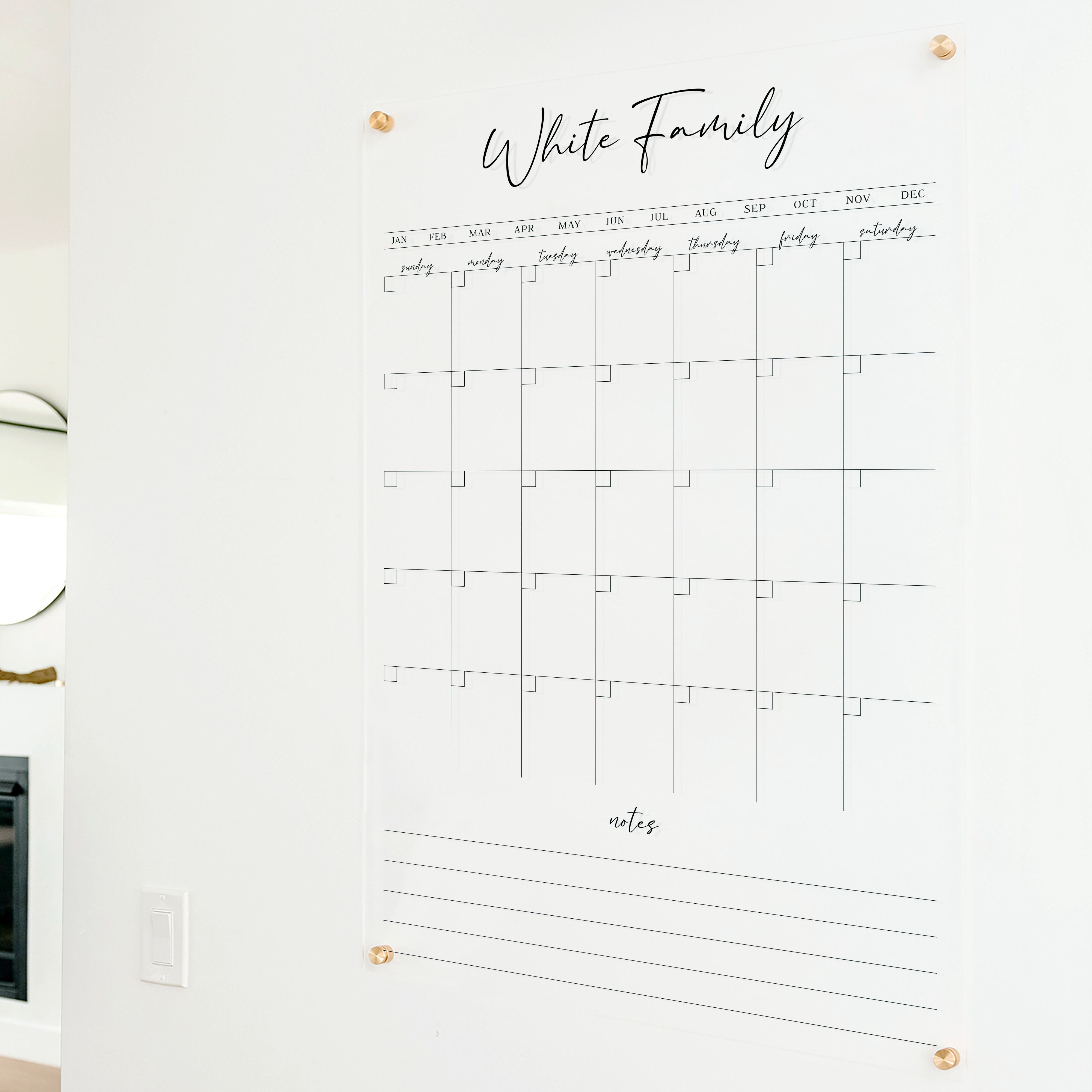 A Dry-erase monthly calender made of acrylic hanging on the wall
