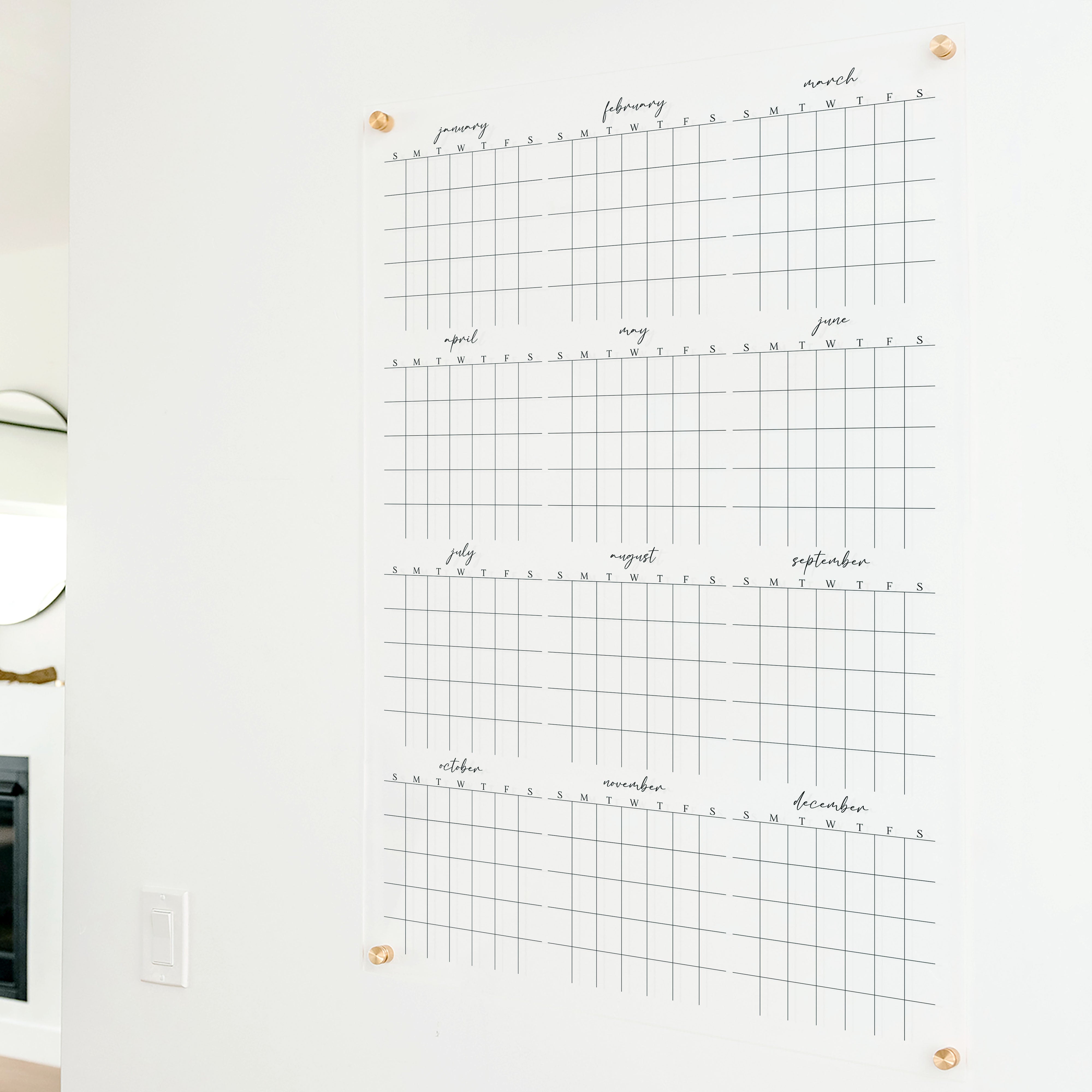 A dry-erase yearly calendar made of acrylic hanging up on the wall