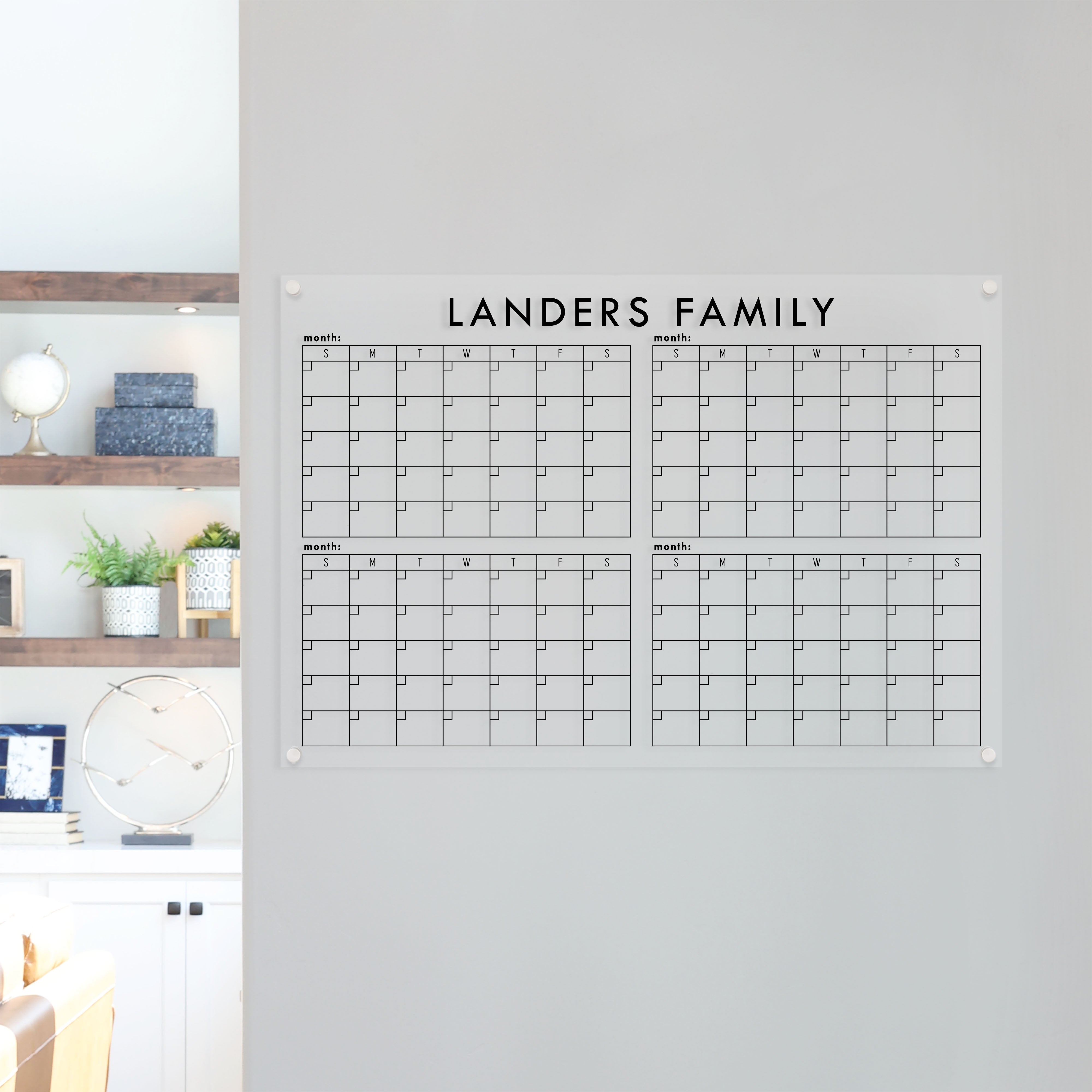 A dry-erase four month calendar made of acrylic hanging on the wall