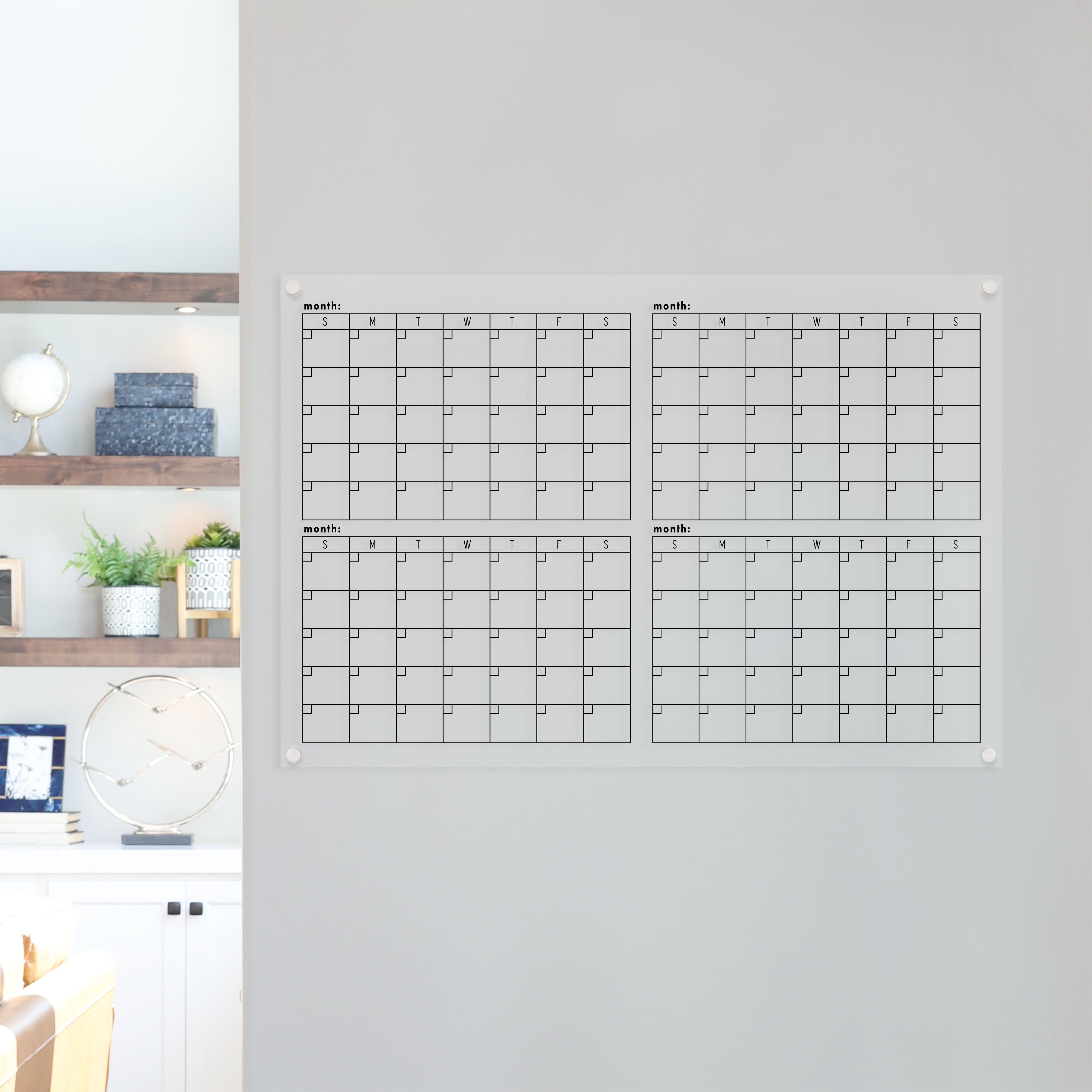 A dry-erase four month calendar made of acrylic hanging on the wall