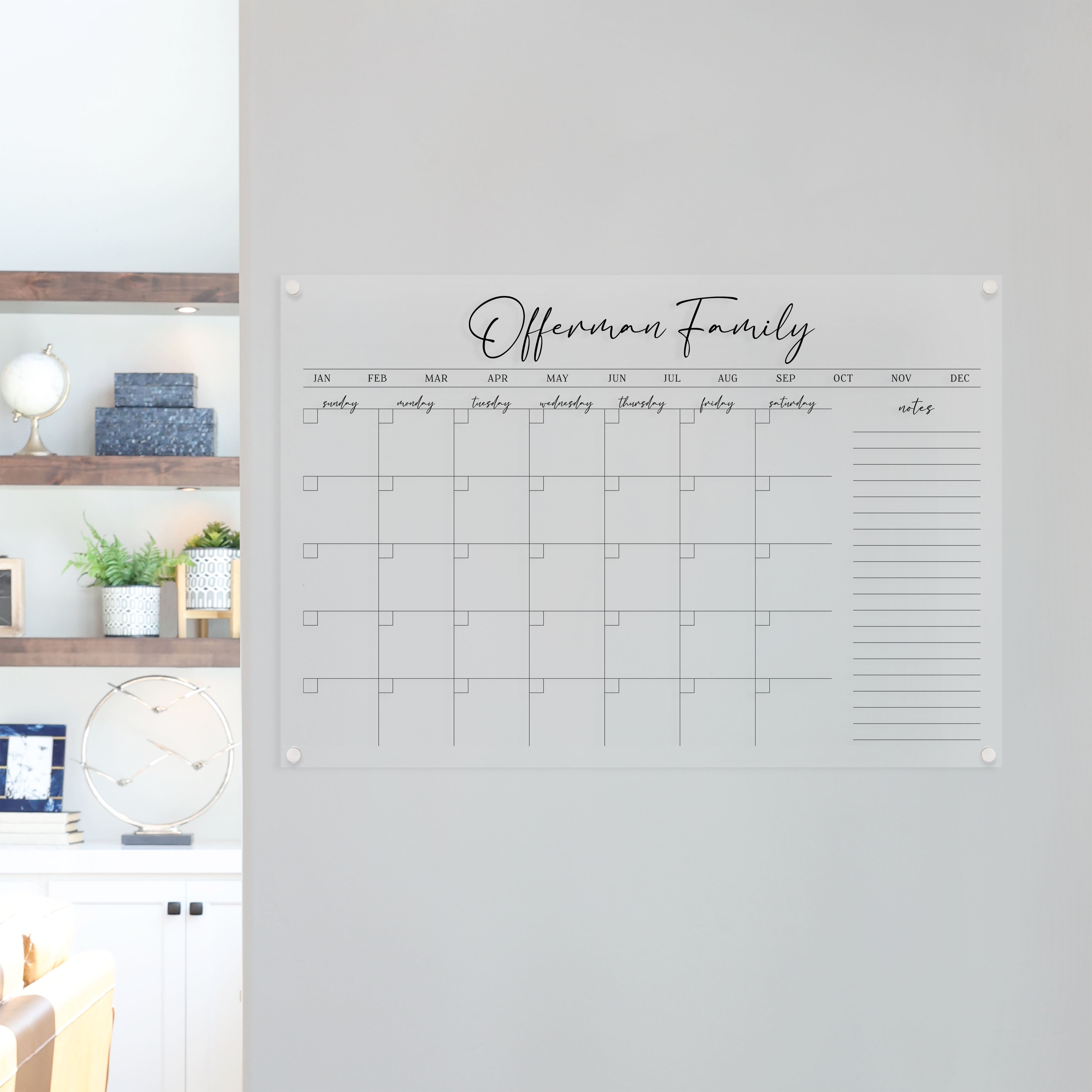 A Dry-erase monthly calender made of acrylic hanging on the wall