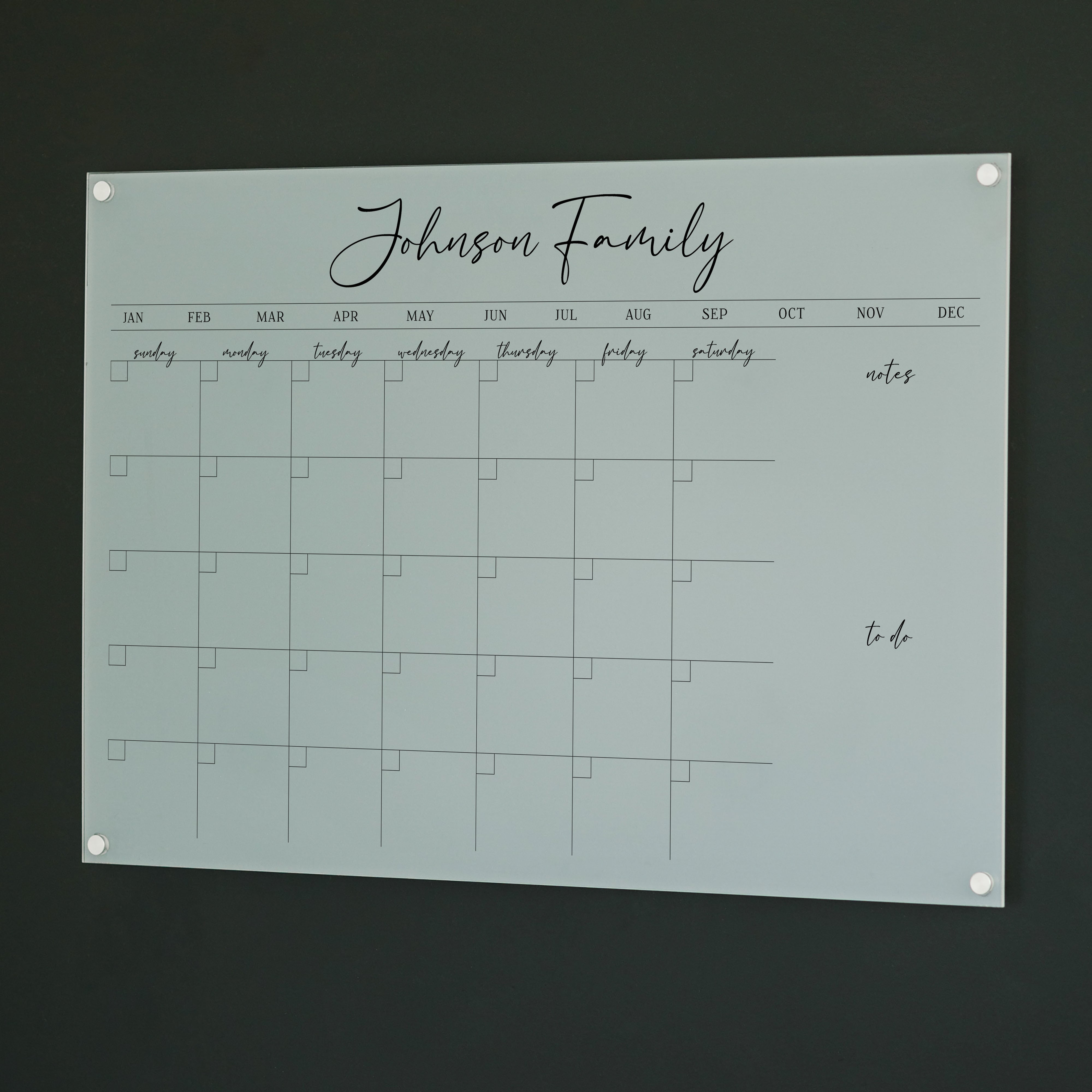 A Dry-erase monthly calender made of acrylic hanging on the wall