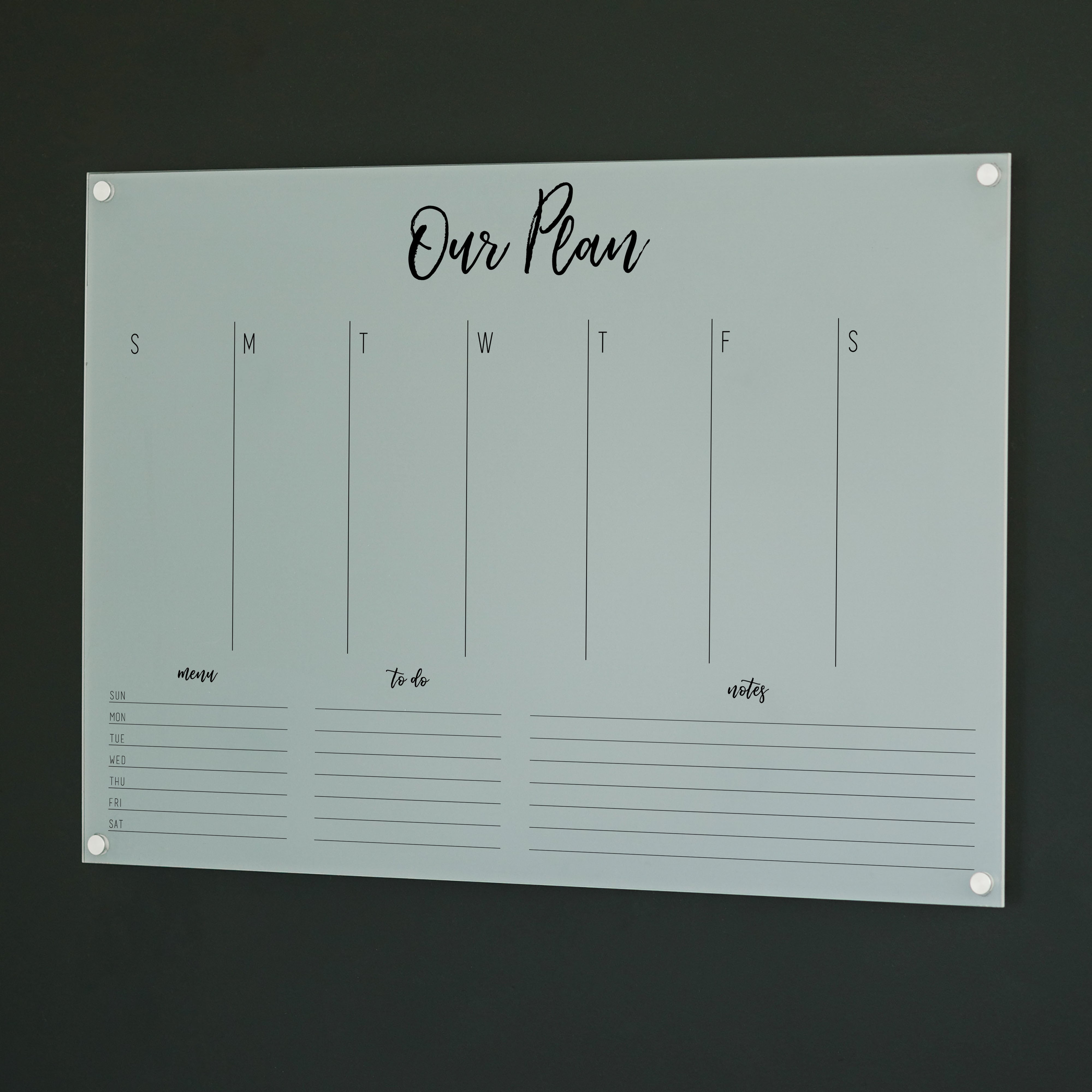 A Dry-erase weekly calender made of acrylic hanging on the wall