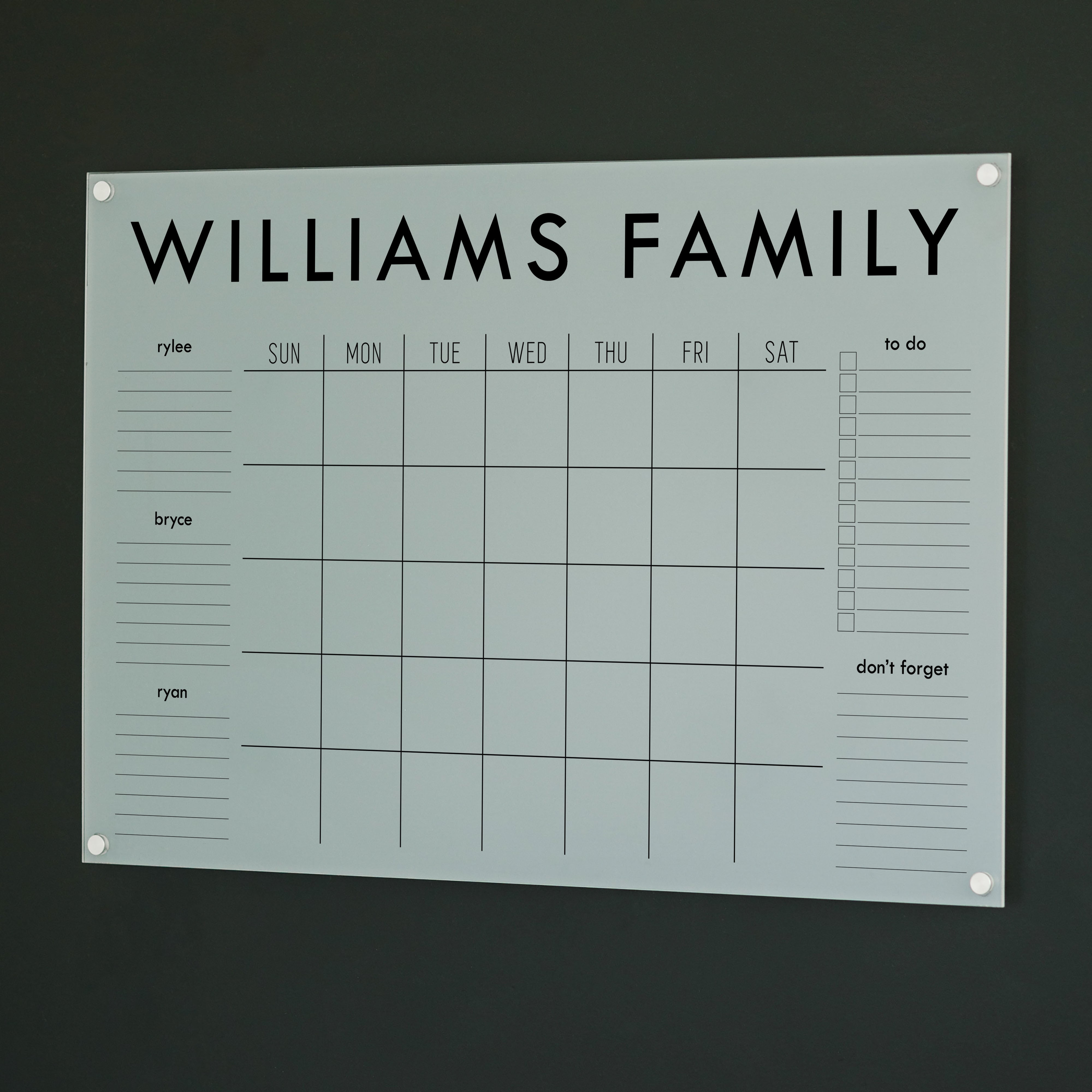 A Dry-erase family command center made of acrylic hanging on the wall