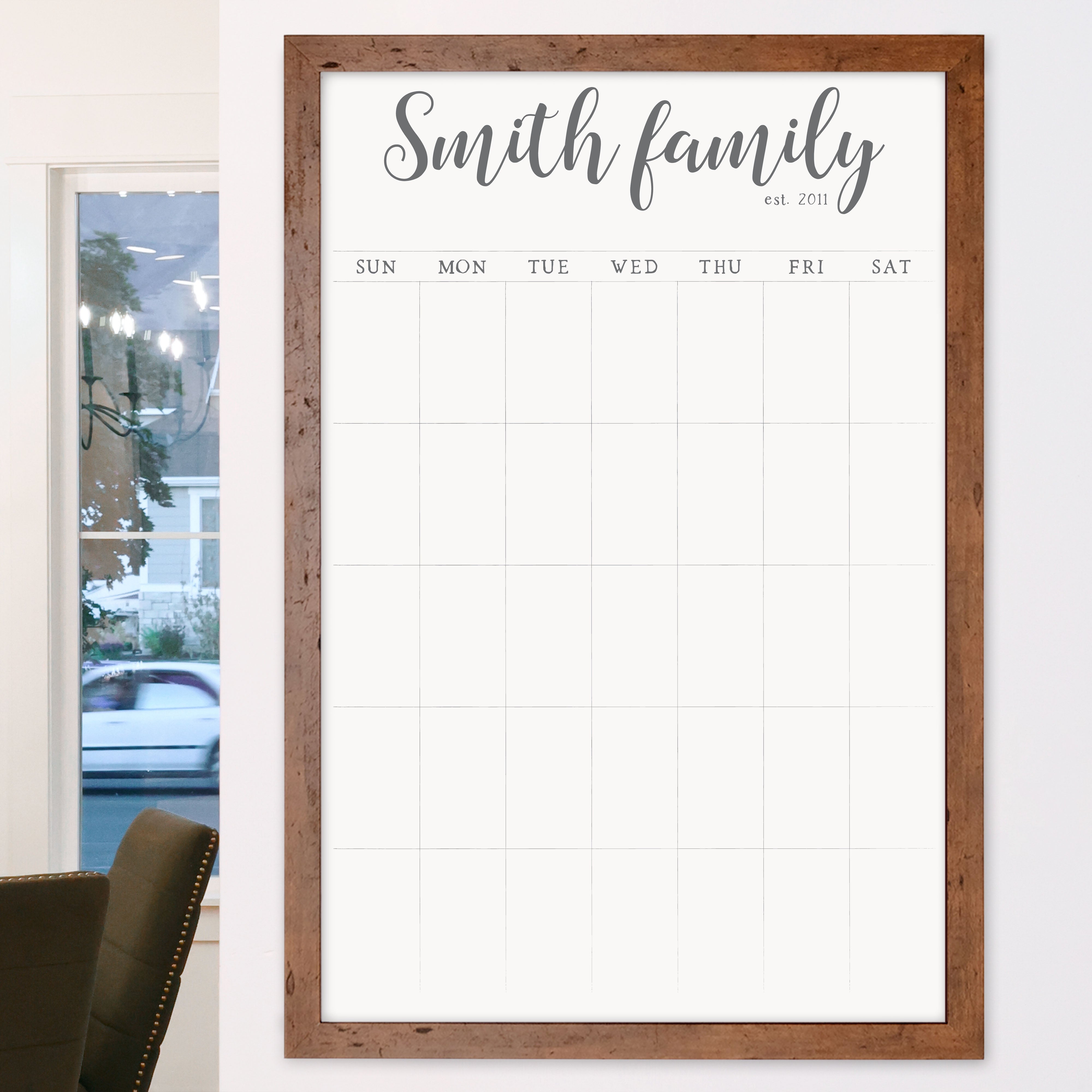 A framed whiteboard monthly calender hanging on the wall
