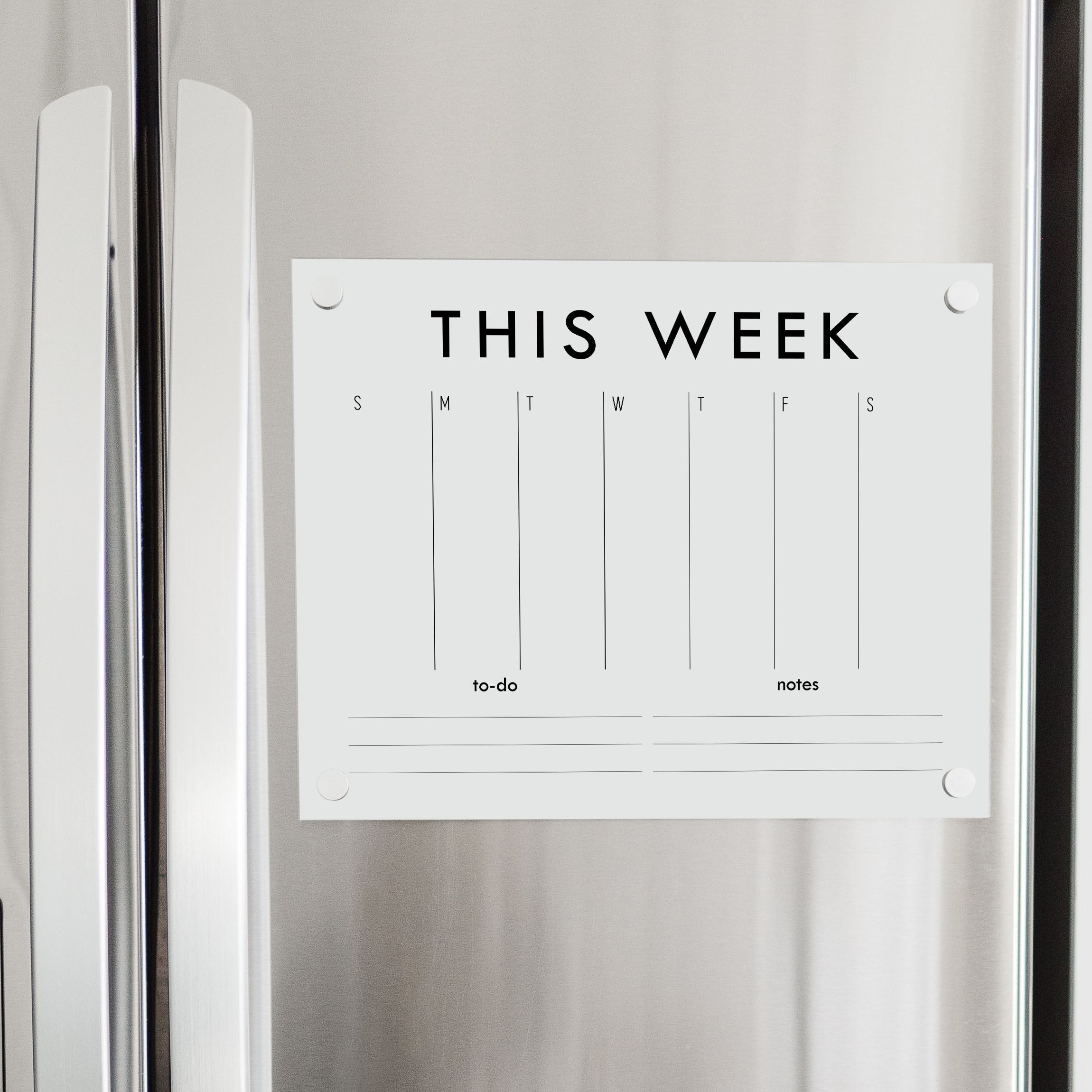 A Dry-erase weekly calender made of acrylic hanging on the fridge