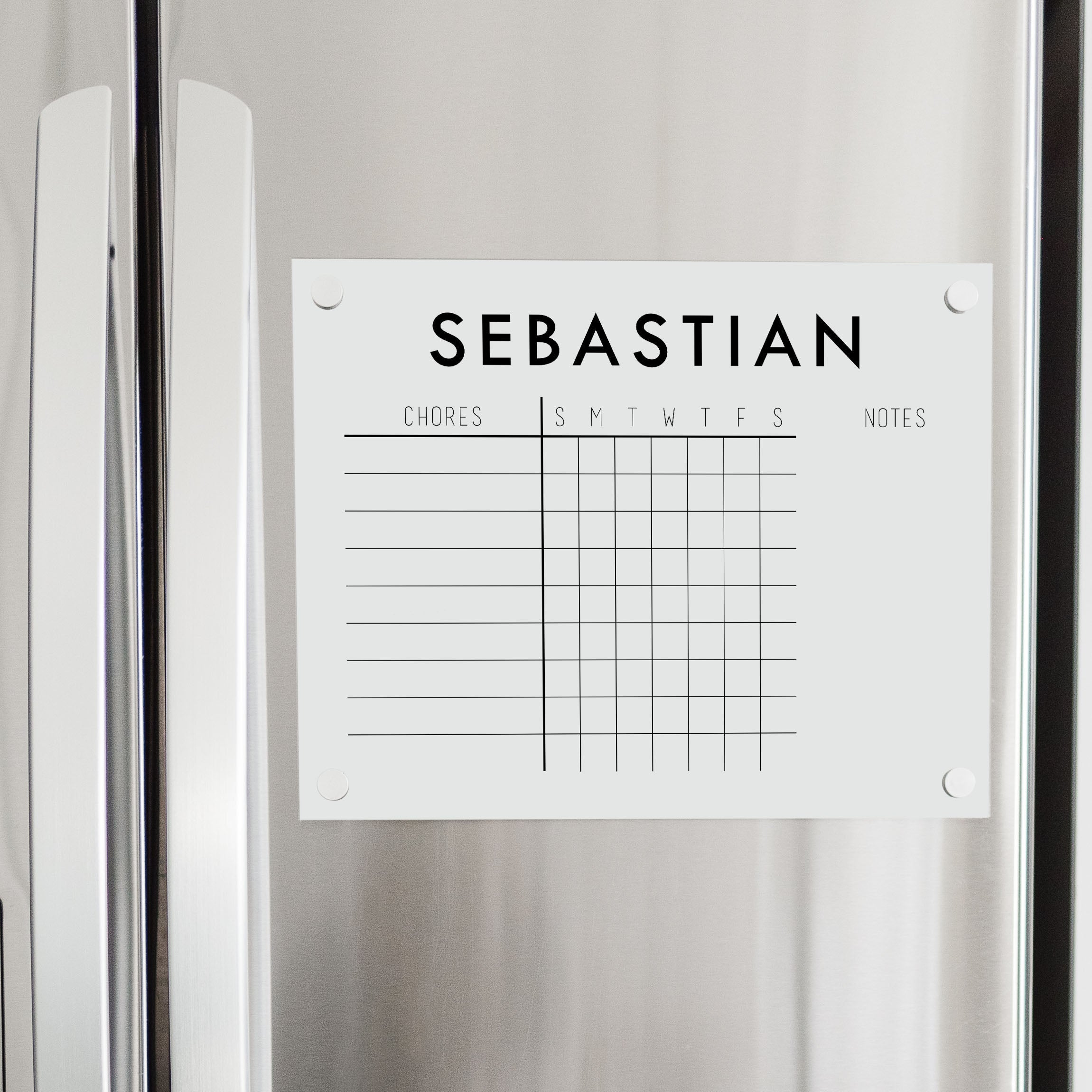 A Dry-erase acrylic chore chart hanging on the fridge