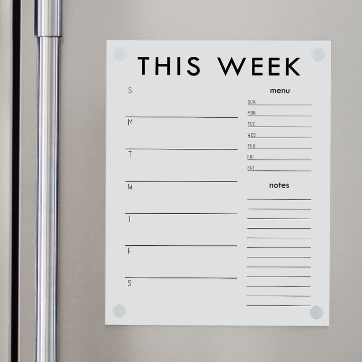 A Dry-erase calendar with a monthly and weekly format made of acrylic hanging on the fridge