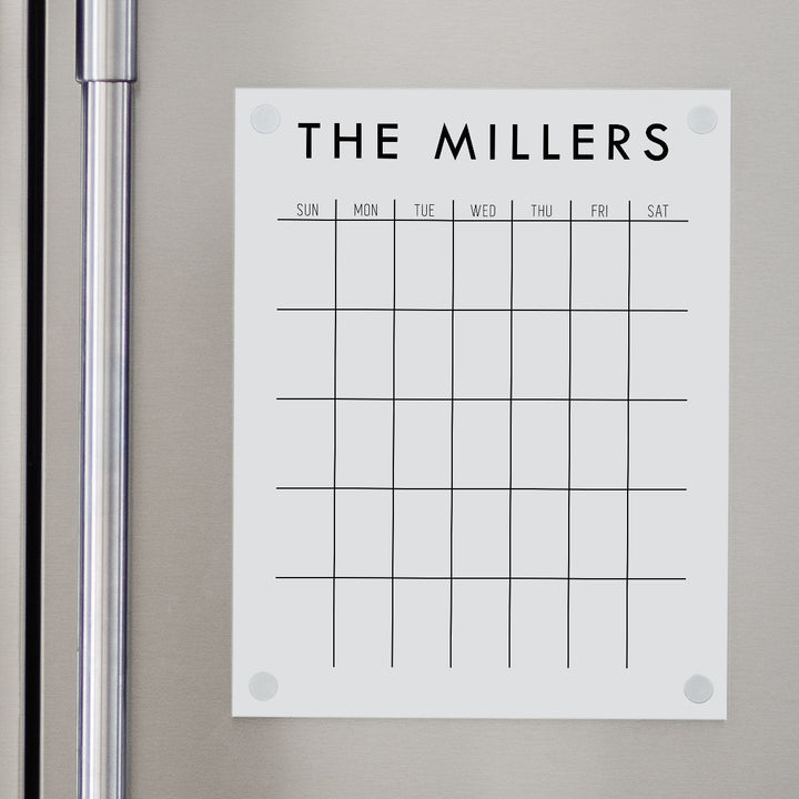 A Dry-erase monthly calender made of acrylic hanging on the fridge