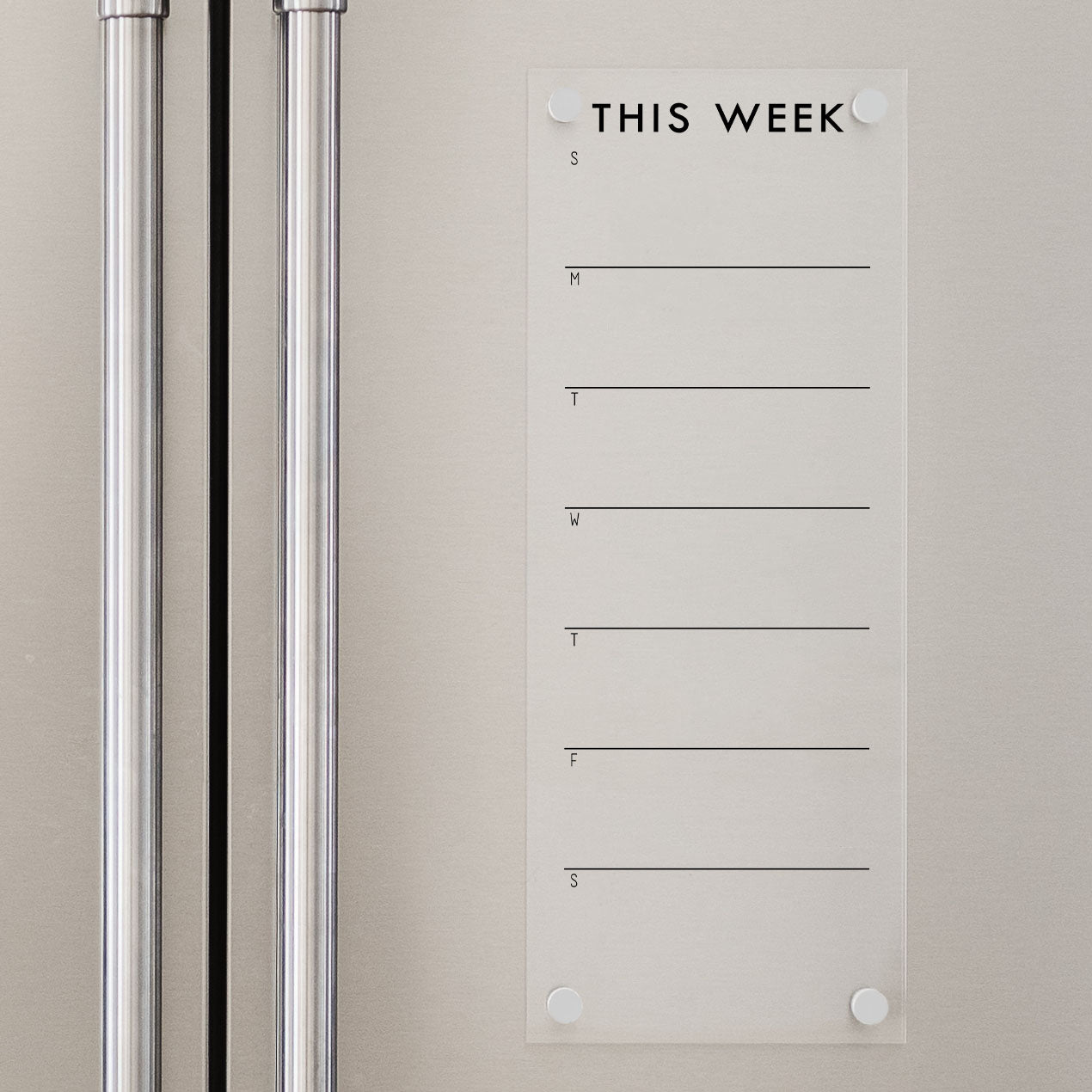 A skinny dry-erase weekly calender made of acrylic hanging on the fridge