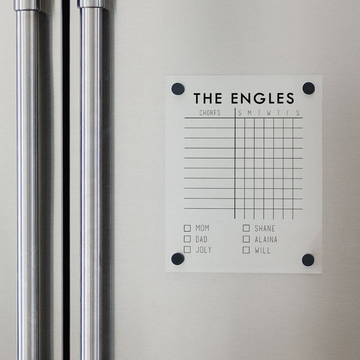 A Dry-erase acrylic chore chart hanging on the fridge