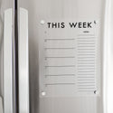 A Dry-erase weekly calender made of acrylic hanging on the fridge